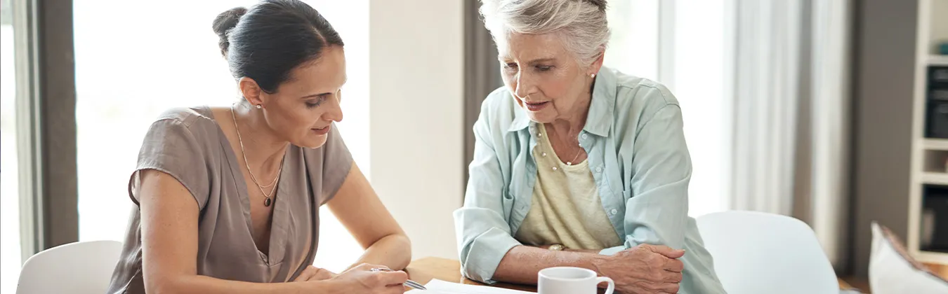 Two people reviewing documents while having coffee.